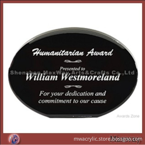 Black oval decent acrylic paperweight with logo and artwork